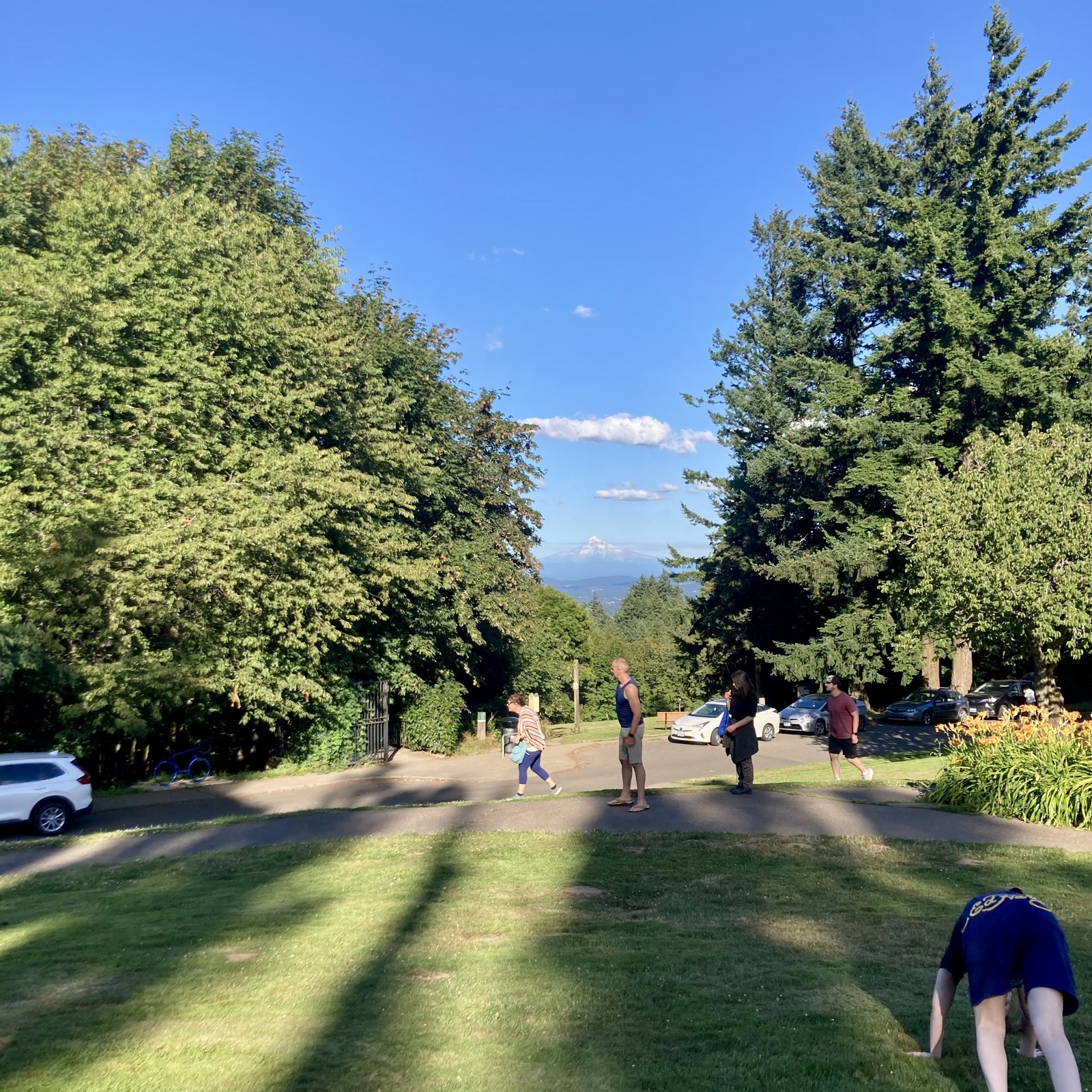 Mountain visible about 2hrs before sunset on a perfect July evening. Lots of people walking through the foreground. A young woman in the foreground doing downward dog oblivious to the fact that like 5 people are trying to take pictures of the mountain